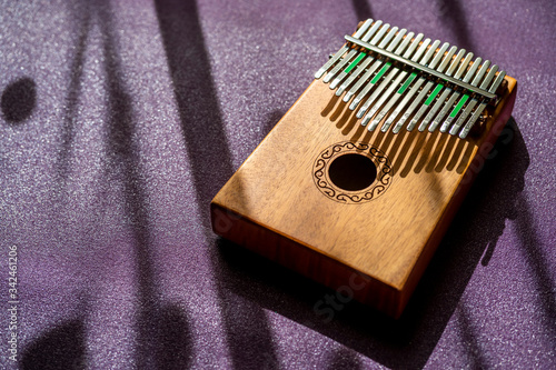 Kalimba musical instrument against a purple background in a beautiful morning light used for hobby activies and relaxation methods through music. Healing, peaceful and relaxing music sounds. photo