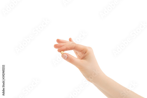 The girl keeps fish oil capsules in her fingers. Palm facing down. Isolated on white background.