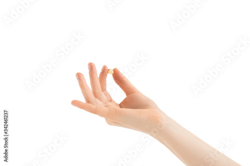 The girl keeps fish oil capsules in her fingers. Palm facing up. Isolated on white background.