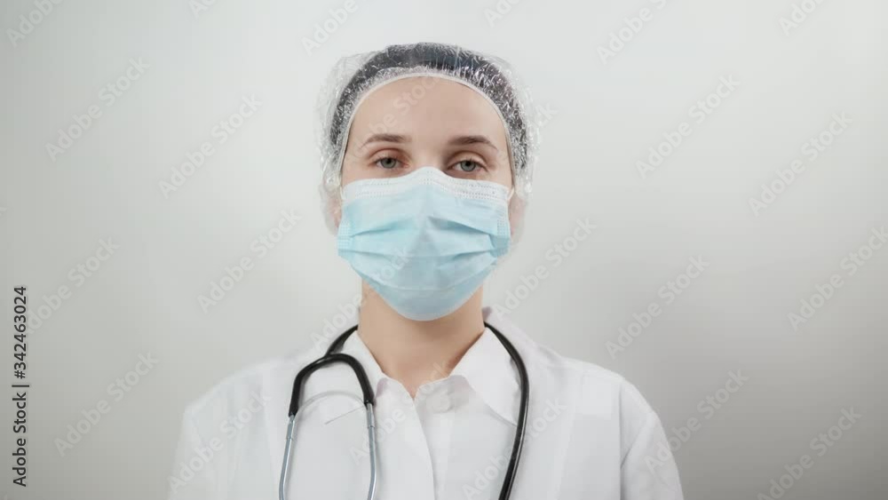 Female nurse standing arms crossed. Confident young woman doctor. Female nurse young pretty woman in green clothes with medical mask posing. Female nurse standing arms crossed. Confident young woman doctor. Female nurse young pretty woman in green clothes with medical mask posing.