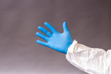 Hand gloves of doctor on gray background
