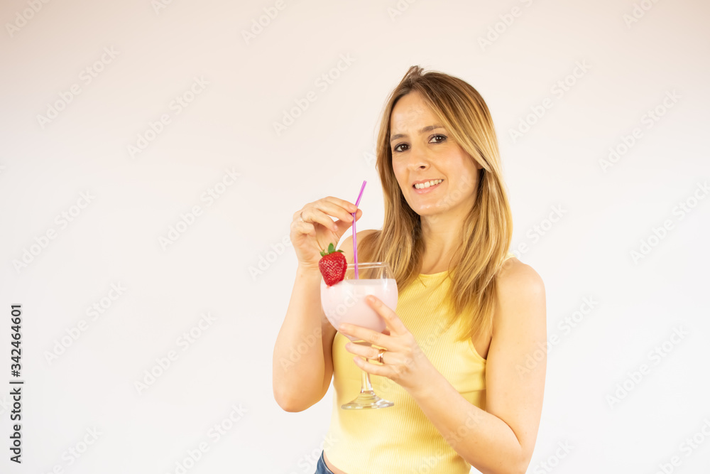 Pretty woman smiling having a strawberry smoothie Pretty woman smiling having a strawberry smoothie