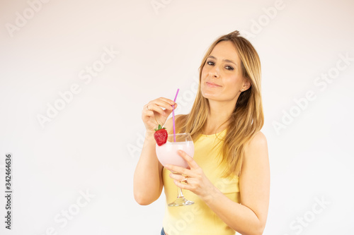 Pretty woman smiling having a strawberry smoothie