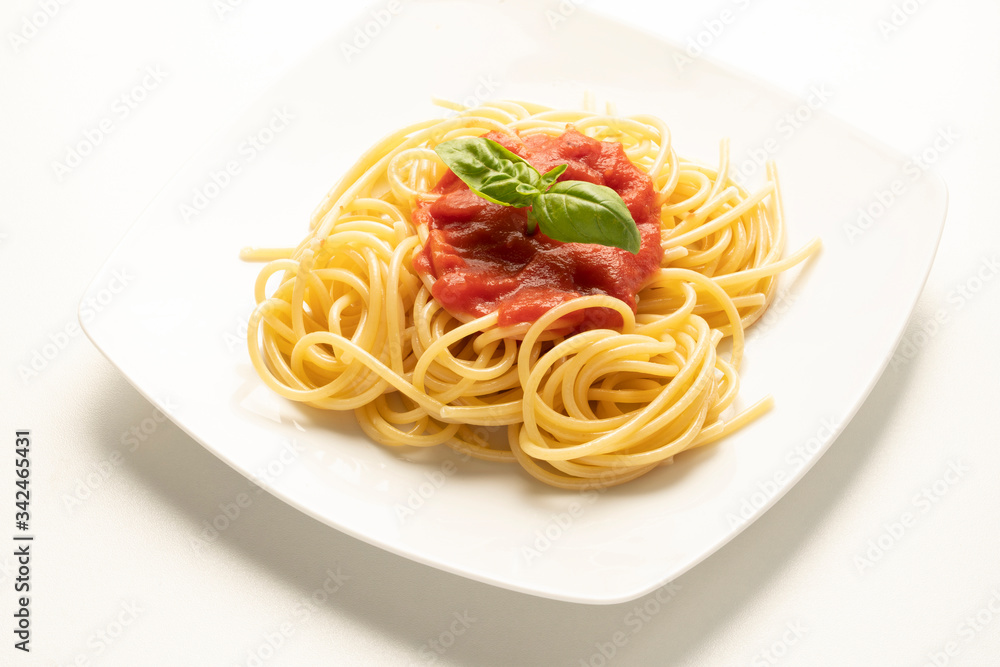dish with spaghetti and tomato sauce on the white table