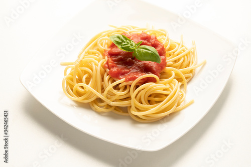 dish with spaghetti and tomato sauce on the white table