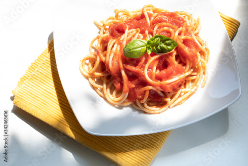 dish with spaghetti and tomato sauce on the white table photo