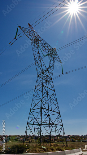 High voltage electrical tower. Electric poles in front of blue sky.