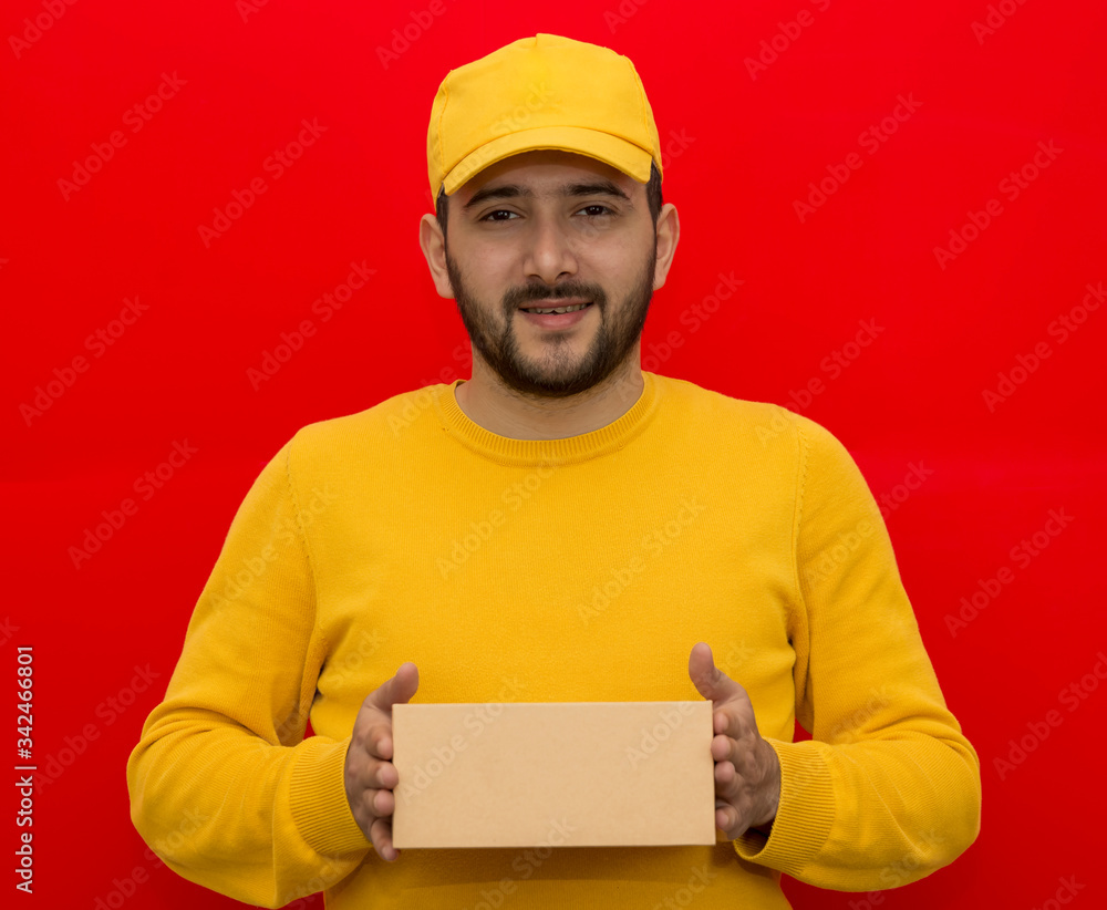 Courier. Deliveryman. The guy is wearing a yellow shirt and cap. Internet delivery. Place for logo and text. Mockup Courier. Deliveryman. The guy is wearing a yellow shirt and cap. Internet delivery. Place for logo and text. Mockup