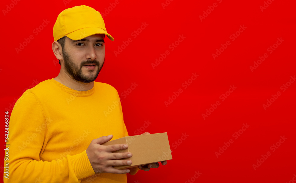 Courier. The guy is wearing a yellow shirt, shirt and cap. Online delivery. Place for logo and text. Layout. Mockup Courier. The guy is wearing a yellow shirt, shirt and cap. Online delivery. Place for logo and text. Layout. Mockup