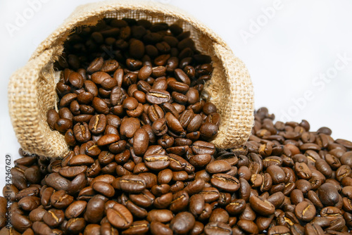 cup of coffee and coffee beans in a vintage sack on isolated white background, top view