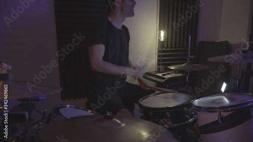 black clothes drummer playing drum in a studio recording session
