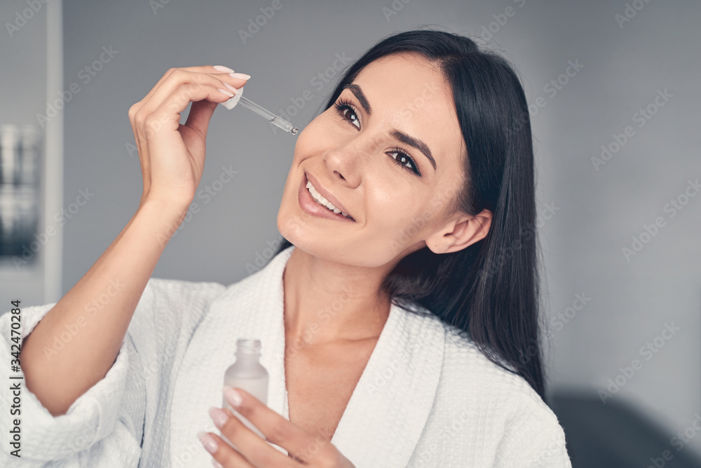 Serene girl holding a bottle of oil Serene girl holding a bottle of oil