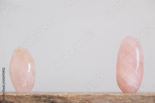 Polished crystals rose quartz gemstone on a wooden table. Copy, empty space for text photo