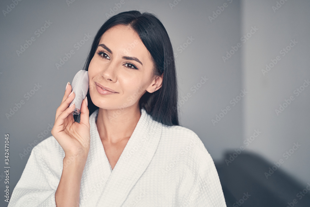 Smiling beautiful girl performing an exfoliation procedure Smiling beautiful girl performing an exfoliation procedure