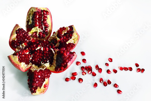 Chopped pomegranate with scattered pomegranate seeds on a light background instagram photo