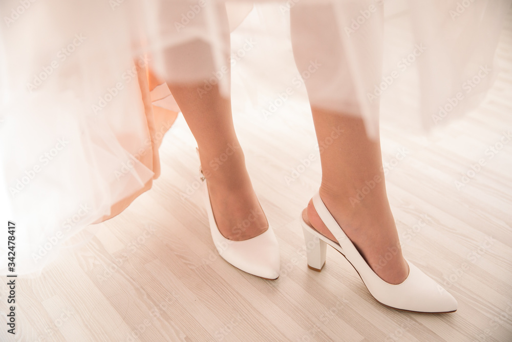 legs of a girl in white shoes under a dress
legs of a girl in white shoes under a dress