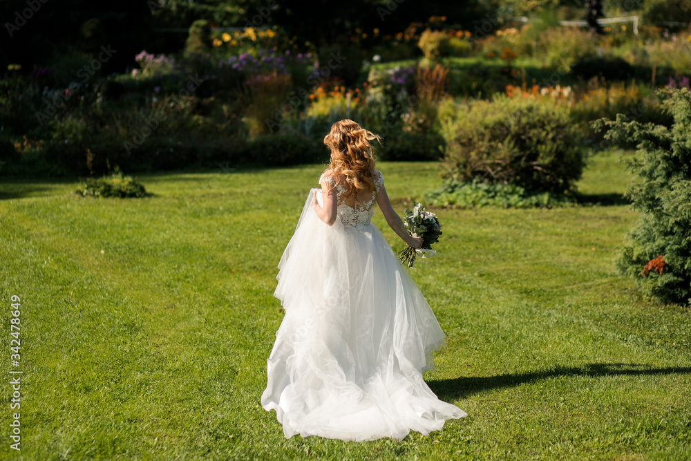 bride with a bouquet in her hands runs on a green lawn
bride with a bouquet in her hands runs on a green lawn