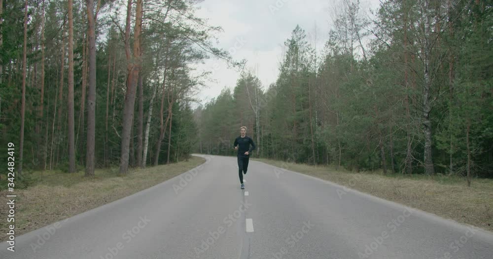 Athlete runs a cross in forest Athlete runs a cross in forest