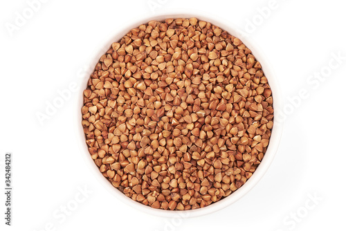 Buckwheat grains in a bowl, top view, isolated on white background