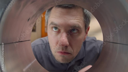 Male engineer looking through the pipe #JBRB180