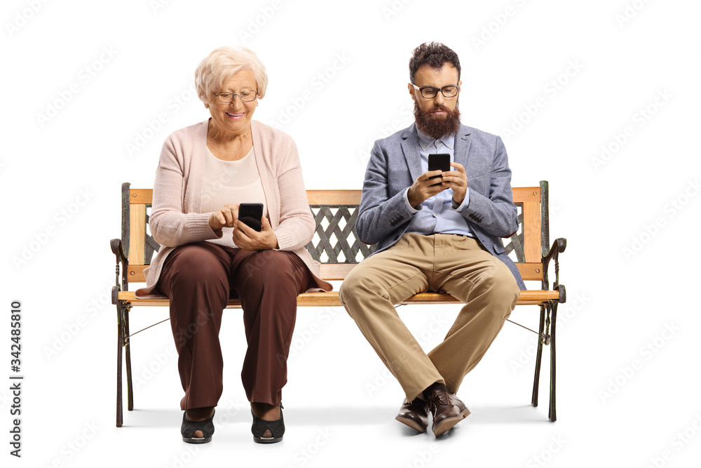 Elderly woman and a young bearded man sitting on a bench and using mobile phones