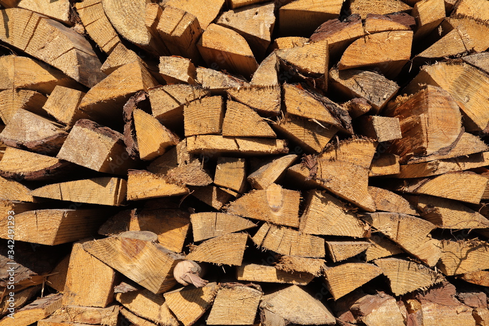 texture of pine firewood. Chipped firewood is on the heap. Woodpile of firewood close-up. A stack of dry firewood, visible texture and cracks in the tree. selective focus. texture of pine firewood. Chipped firewood is on the heap. Woodpile of firewood close-up. A stack of dry firewood, visible texture and cracks in the tree. selective focus.