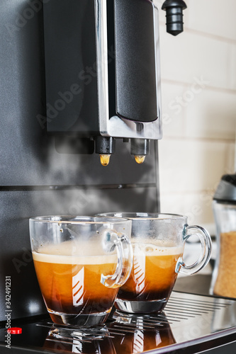 aromatic natural coffee made in a coffee machine. Two cups of hot espresso