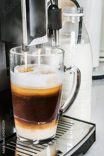 flavorful natural cappuccino made in a coffee machine. glass glass with hot drink with cappuccino foam