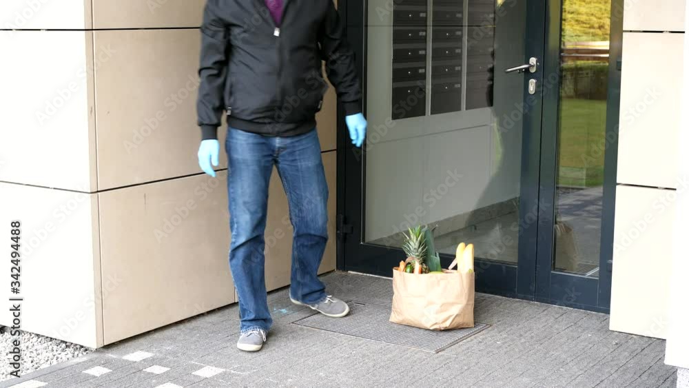 food delivery courier gloves leaving grocery bag in front door food delivery courier gloves leaving grocery bag in front door