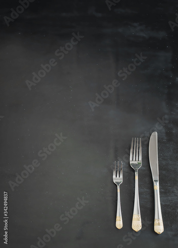 beautiful silver fork, spoon and knife on a black background 