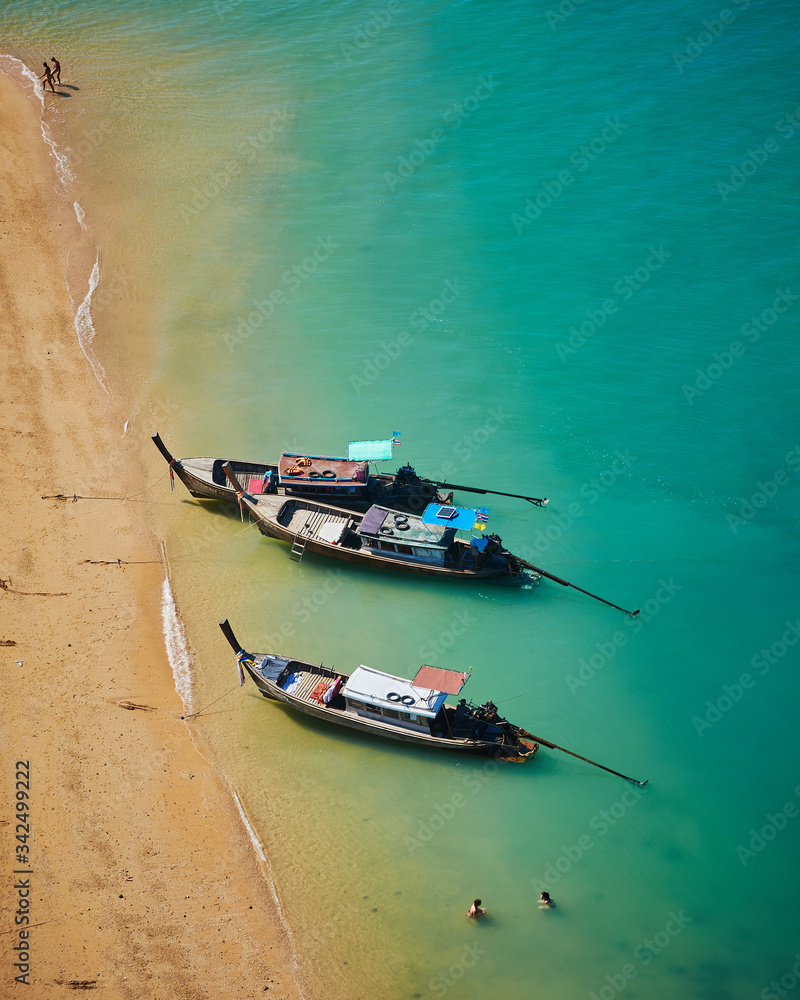 Traditional long tail Thai boats parked on Beautiful beach with a white sandbar and blue sea at Koh Nok island tourist destination - Koh Yao Noi , Thailand