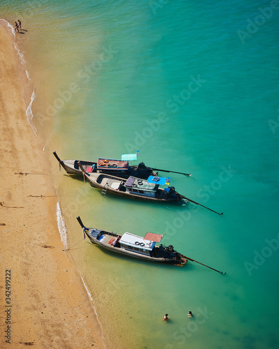 Traditional long tail Thai boats parked on Beautiful beach with a white sandbar and blue sea at Koh Nok island tourist destination - Koh Yao Noi , Thailand photo