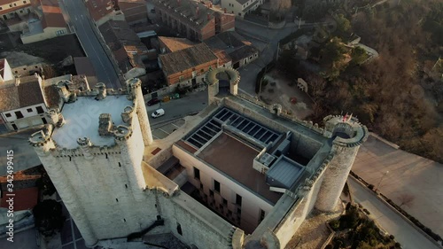 Cinematic medieval castle with homes in the background at sunset in Spain