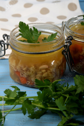 tripe soup in glass jars with fresh green parsley next to bread