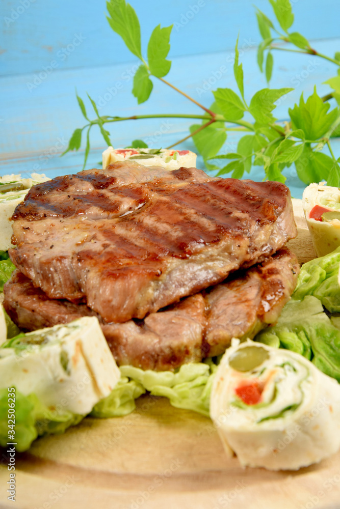 Sliced tortilla with vegetables next to fried grilled steak Sliced tortilla with vegetables next to fried grilled steak