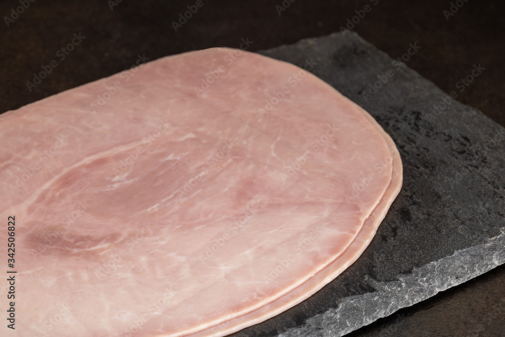 tranches de jambon blanc de Paris sur une planche à découper en ardoise
