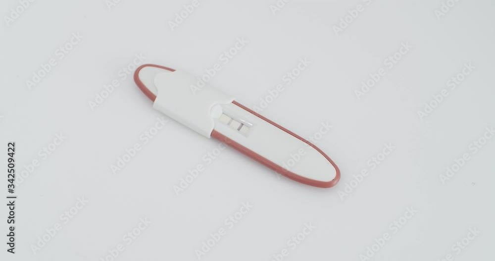 Female hand putting a pregnancy test with a positive result on a white table, 4k Female hand putting a pregnancy test with a positive result on a white table, 4k
