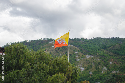 The flutter of Bhutanese National flag featuring the Thunder dragon, the emblem of the country in front of Thimphu Dzong