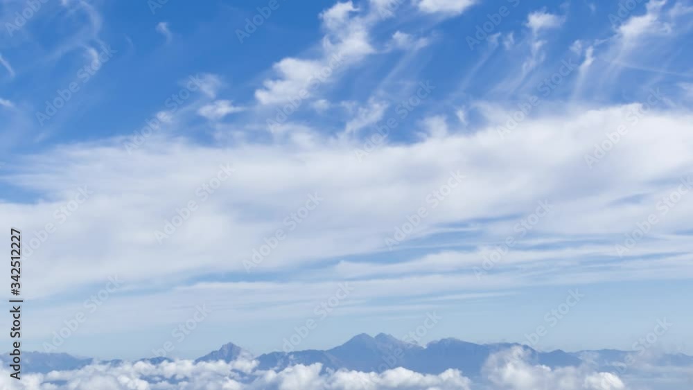 Zoom out time lapse of moving clouds over valley and mountains. Old concrete WW2 bunkers on hilltop. Alps mountain range in distance, Slovenia