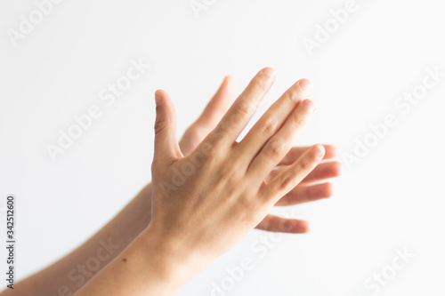 Detail of hands clapping on white background