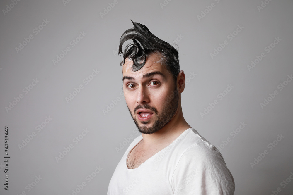 Happy bearded man with surprising face and posing over grey background with wet hair. Hair care concept. Happy bearded man with surprising face and posing over grey background with wet hair. Hair care concept.