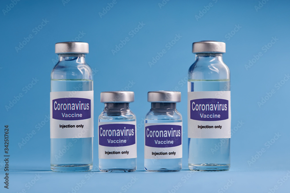 Corona virus vaccine for injection in sealed vials. Vaccine injection in sealed bottles and medical disposable plastic syringe against a blue background. Corona virus vaccine for injection in sealed vials. Vaccine injection in sealed bottles and medical disposable plastic syringe against a blue background.