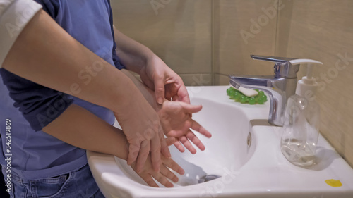 Mother Helping Son To Wash His Little Hands