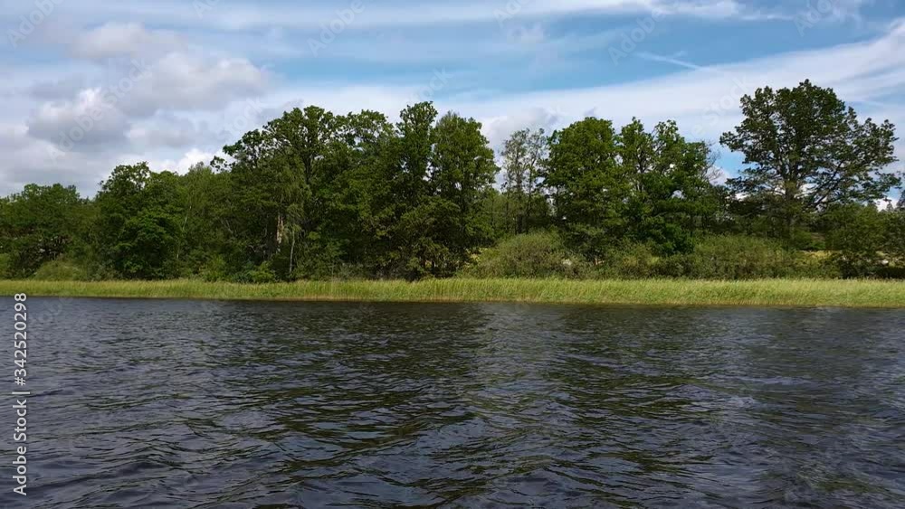Slow motion. Gorgeous view of nature landscape. High trees on lake coast. Thunder sky with gray clouds background. Cloudy summer day on nature. Slow motion. Gorgeous view of nature landscape. High trees on lake coast. Thunder sky with gray clouds background. Cloudy summer day on nature.