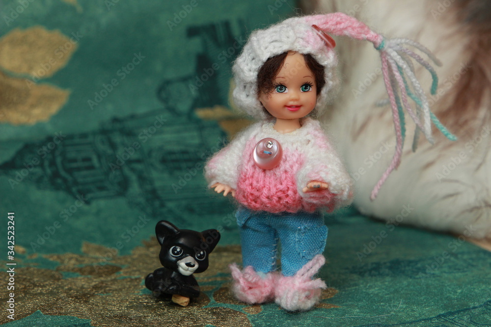 Fototapeta premium A small beautiful child's doll, posing in beautiful places. 