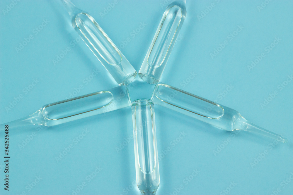 five medical ampoules isolated on blue background five medical ampoules isolated on blue background