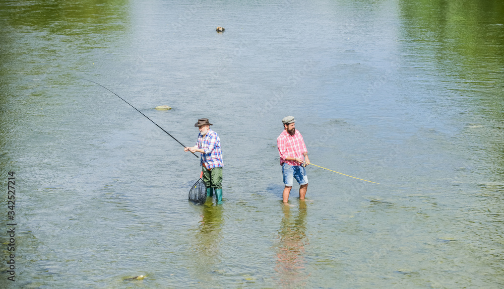 who will win. hobby and sport activity. Trout bait. Big game fishing. male friendship. recreation and leisure outdoor. two happy fisherman with fishing rod and net. father and son fishing. adventures who will win. hobby and sport activity. Trout bait. Big game fishing. male friendship. recreation and leisure outdoor. two happy fisherman with fishing rod and net. father and son fishing. adventures