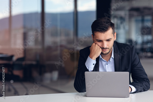 Fotografie Portrait of worried young man at workplace. Stress concept