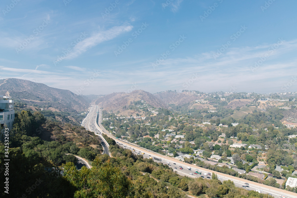 Los Angeles view of the highway from a mountain at sunset, clear blue skies