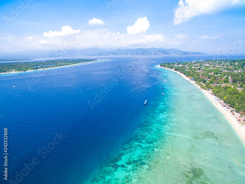 Lombok Indonesia June, 4 2020 : Tropical Island. View of nice tropical empty sandy beach, turquoise water with boats in gili trawangan lombok